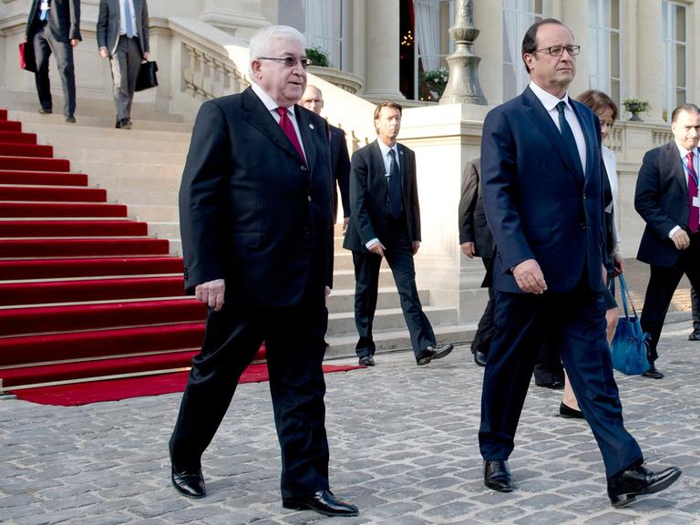 Frankreichs Präsident Francois Hollande (r.) und sein irakischer Amtskollege Fuad Masum passieren am 15. September 2014 den Weg vor dem französischen Außenministerium in Paris nach der Eröffnung einer internationalen Konferenz zur Lage im Irak.