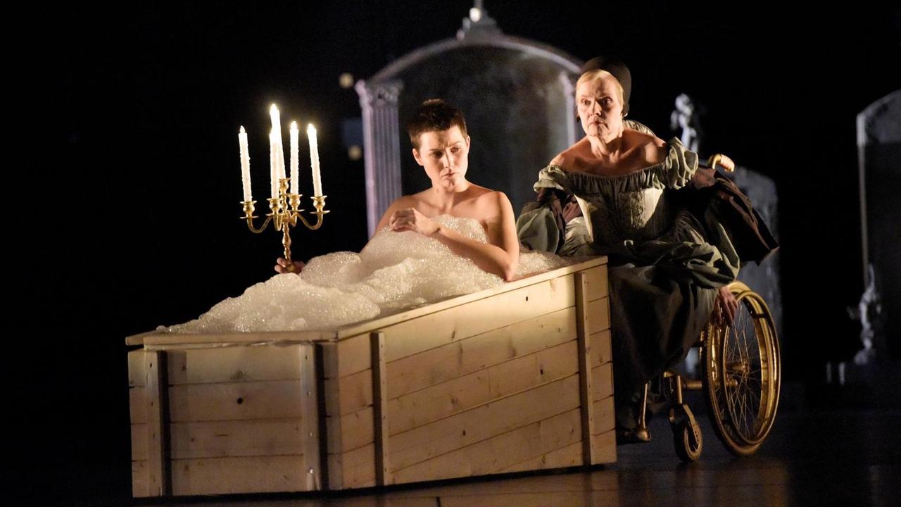Romeo und Julia von William Shakespeare in einer Inszenierung von Oliver Frljić am Schauspiel Stuttgart. Nina Siewert als Julia im Sarg und Gabriele Hintermaier als Lady Capulet im Hintergrund