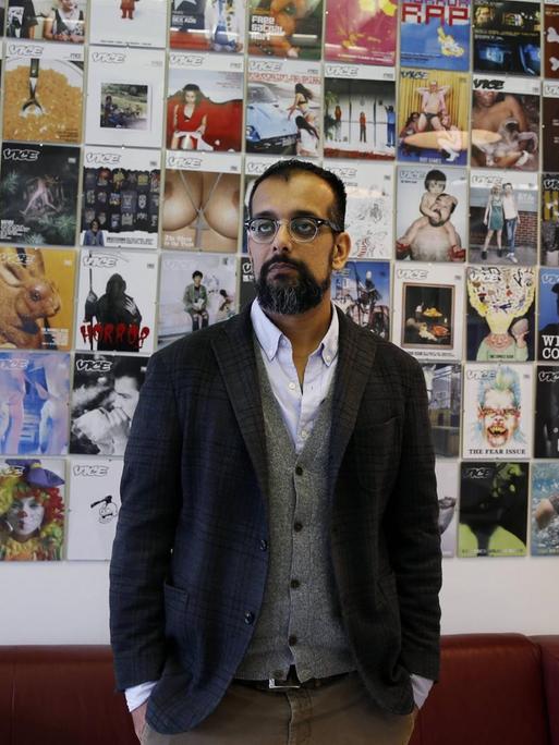 Ein Mann vor einer Wand mit "Vice"-Covern
