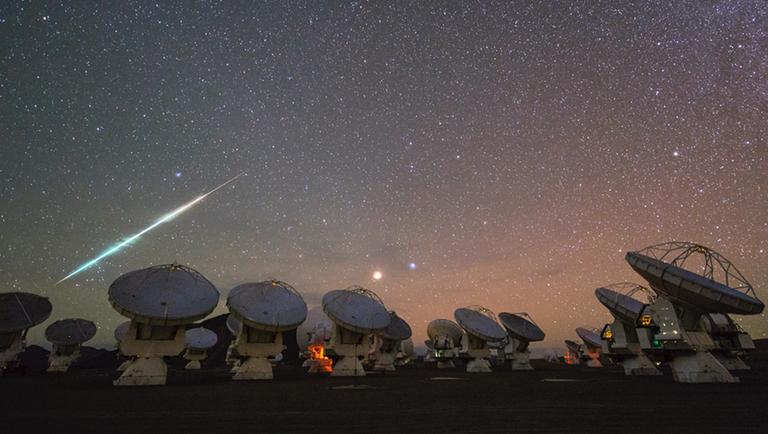 Eine besonders helle Sternschnuppe über der Teleskopanlage ALMA in Chile