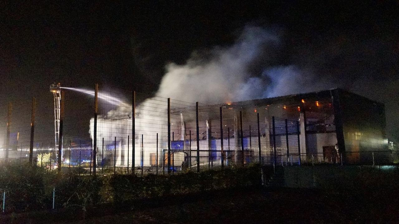 Feuerwehrleute löschen am Morgen des 25.08.2015 in Nauen (Brandenburg) einen Brand in der Turnhalle des Oberstufenzentrums Havelland.