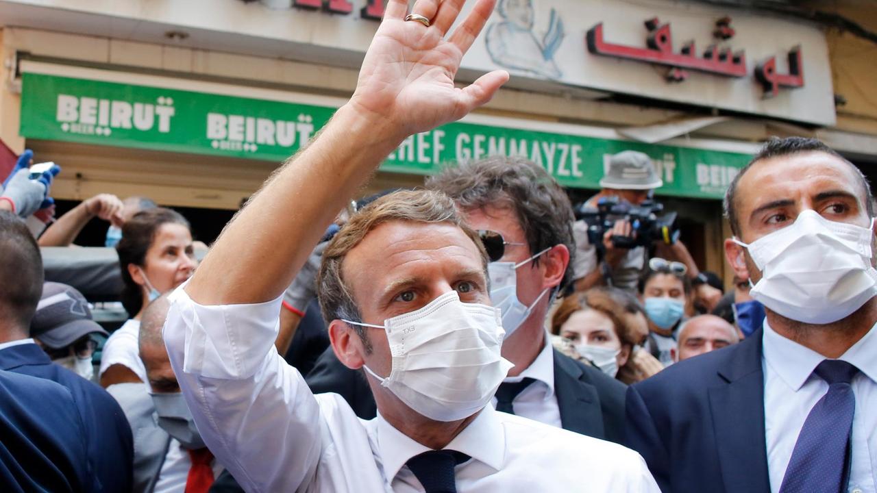Der franzöische Präsident Emmanuel Macron winkt bei seinem Besuch in einer Menschenmenge in Beirut, Libanon, nach der verheerenden Explosion.