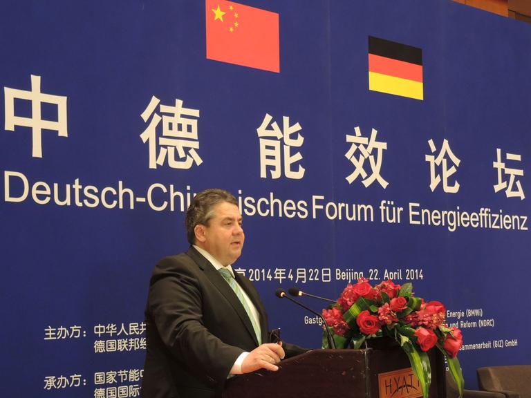 Bundeswirtschaftsminister Sigmar Gabriel (SPD) hält in Peking bei einem deutsch-chinesischen Forum für Energieeffizienz vor einer Plakatwand stehend eine Rede.