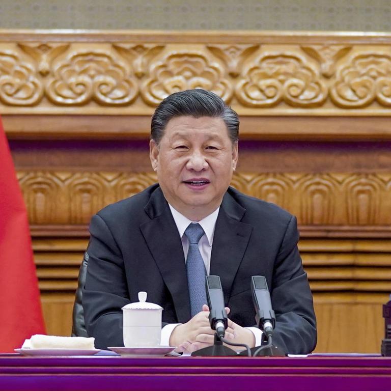 Der chinesische Präsident Xi Jinping sitzt an einem Tisch mit Mikrofonen während einer Videokonferenz im April.