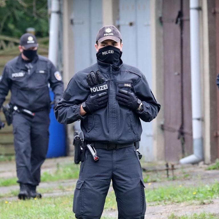 01.10.2020, Mecklenburg-Vorpommern, Löcknitz: Polizisten durchsuchen einen Garagenkomplex.