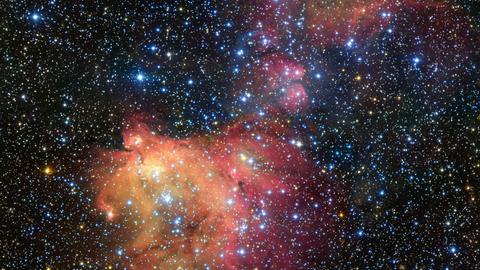 Der Sternhaufen N55 inmitten bunter Gas- und Staubwolken