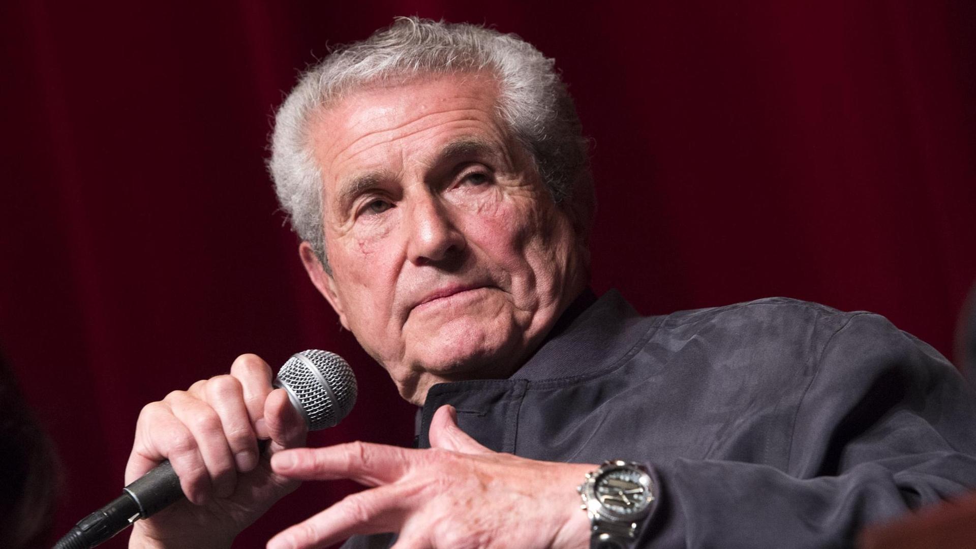 Director Claude Lelouch hält beim French Film Festival in Los Angeles ein Mikrofon in der Hand. 