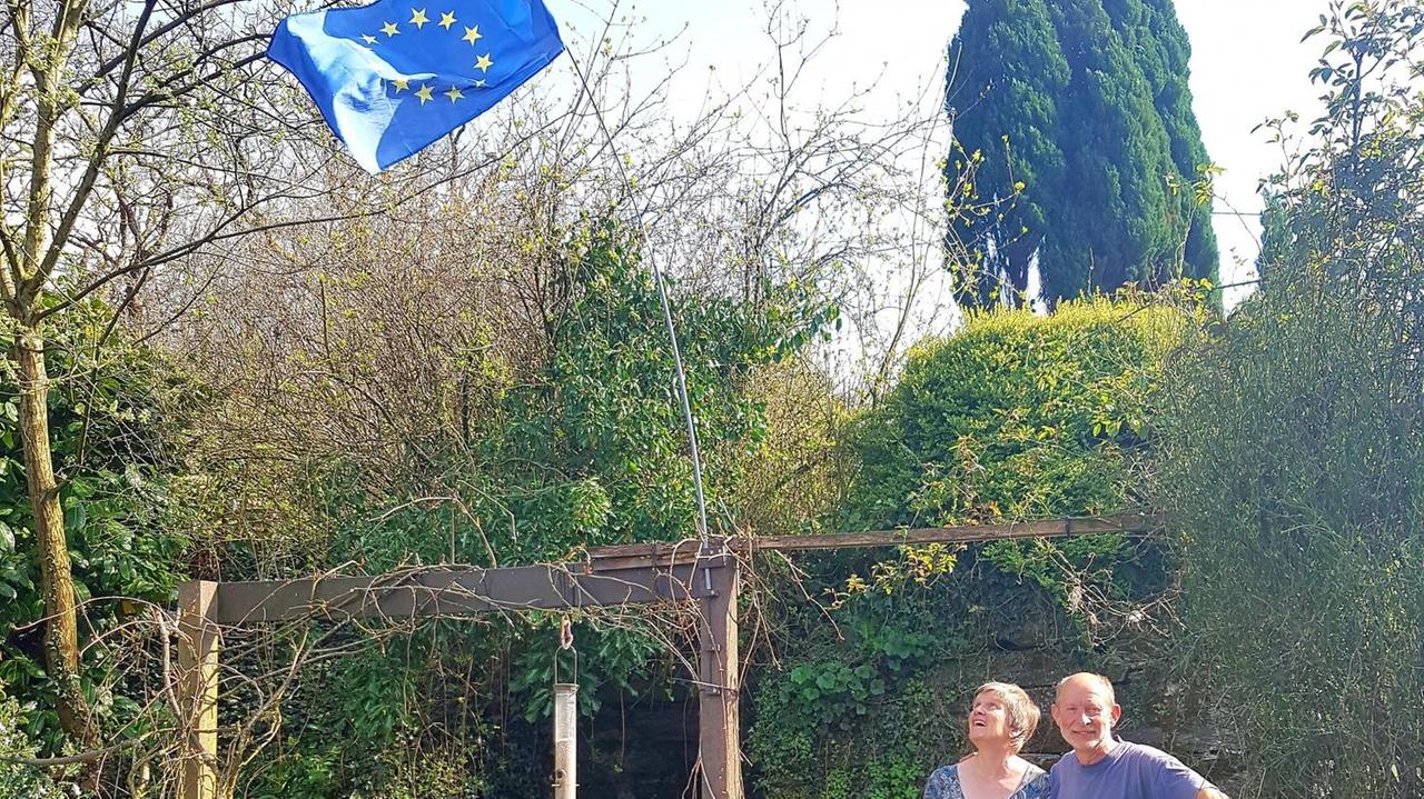Die Waliser Judith und Iain mit ihrer blauen EU-Flagge im grünen Garten.
