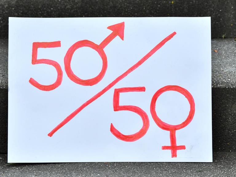 15.07.2020, Thüringen, Weimar: Ein Plakat mit einer symbolischen Darstellung der Parität steht am Rande einer Demonstration auf der Eingangstreppe vor Beginn der Urteilsverkündung im Thüringer Verfassungsgerichtshof. Parteien müssen in Thüringen ihre Kandidatenlisten für Landtagswahlen nicht abwechselnd mit Männern und Frauen besetzen. Das hat der Verfassungsgerichtshof entschieden und eine entsprechende Paritätsregelung im Landeswahlgesetz gekippt. Damit war eine Klage der AfD erfolgreich. Foto: Martin Schutt/dpa-Zentralbild/dpa | Verwendung weltweit