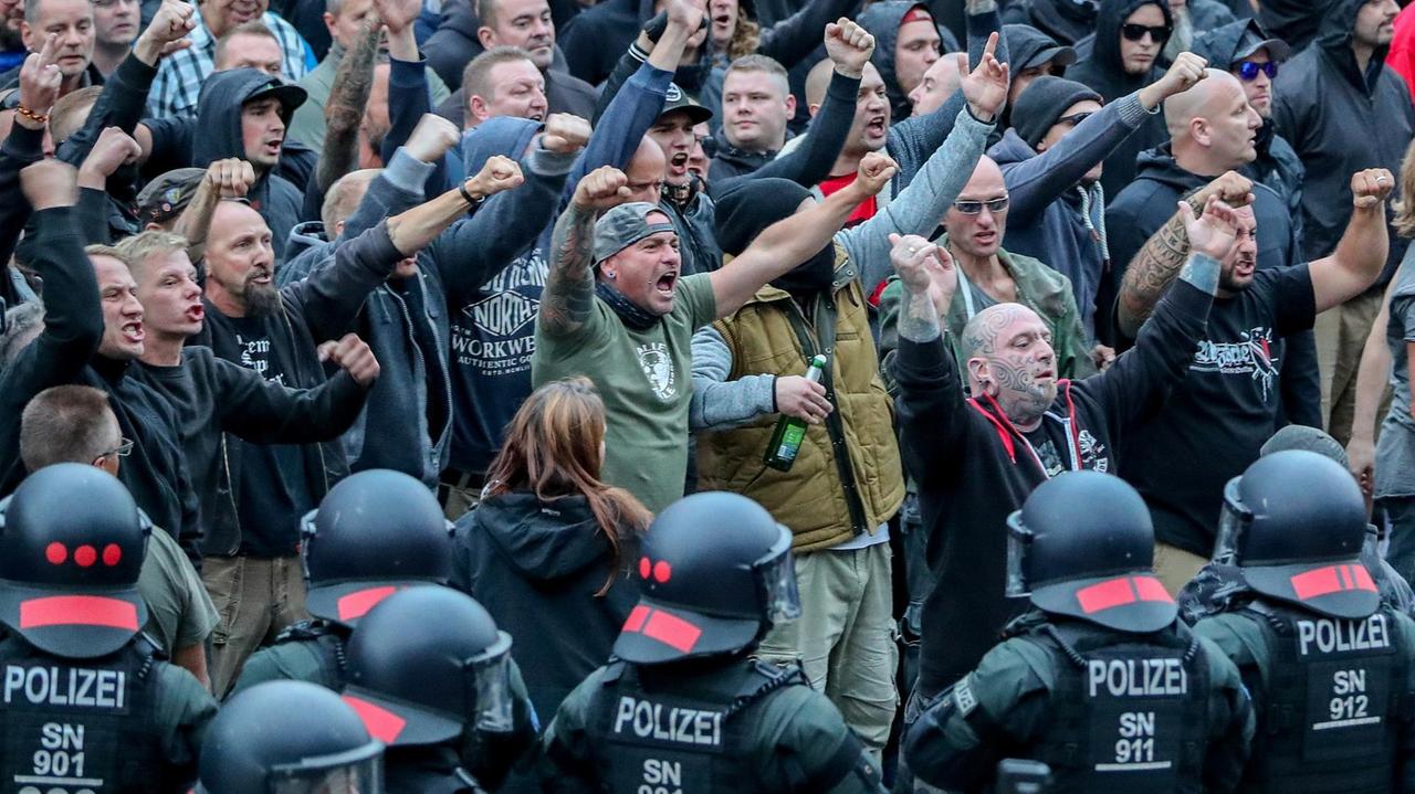 27. August 2018 in Chemnitz: Demonstranten der rechten Szene gestikulieren und drohen den Gegendemonstranten Gewalt an.