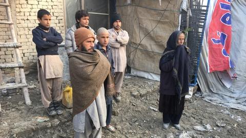 Mohammad Ahmad und einige seiner Familienangehörigen vor der notdürftig zusammen gemauerten Unterkunft