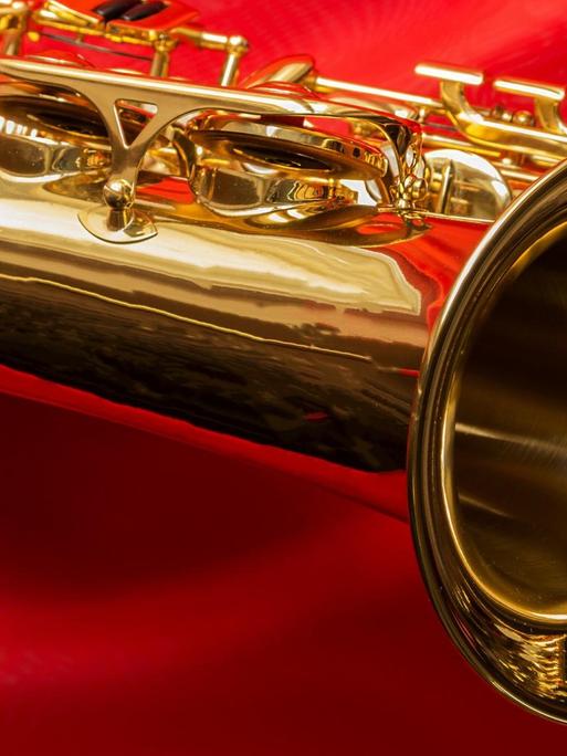 Ein geputztes, golden strahlendes Saxophon liegt auf einem knallrotem Tuch.