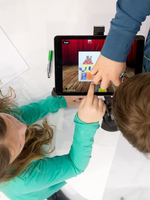 Kinder arbeiten am 25.03.2014 auf der Bildungsmesse Didacta in Stuttgart (Baden-Württemberg) an dem Messestand des Madsack Mediastore an einem iPad. Die Bildungsmesse läuft vom 25. bis 29.03.2014.