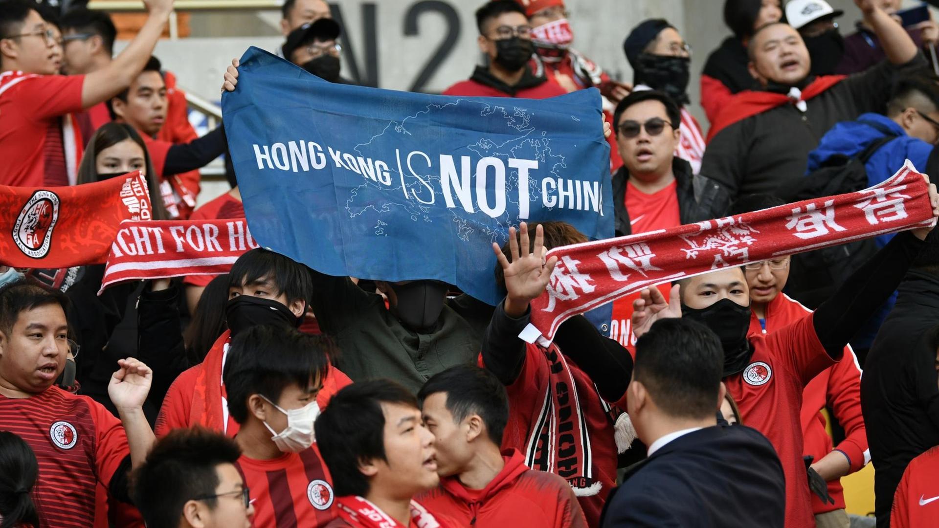 Fans von Hongkong halten ein Banner mit der Aufschrift "Hong Kong ist nicht China" während des Spiels zwischen Hongkong und China bei Ostasiatischen Meisterschaft in Südkorea im Dezember 2019.