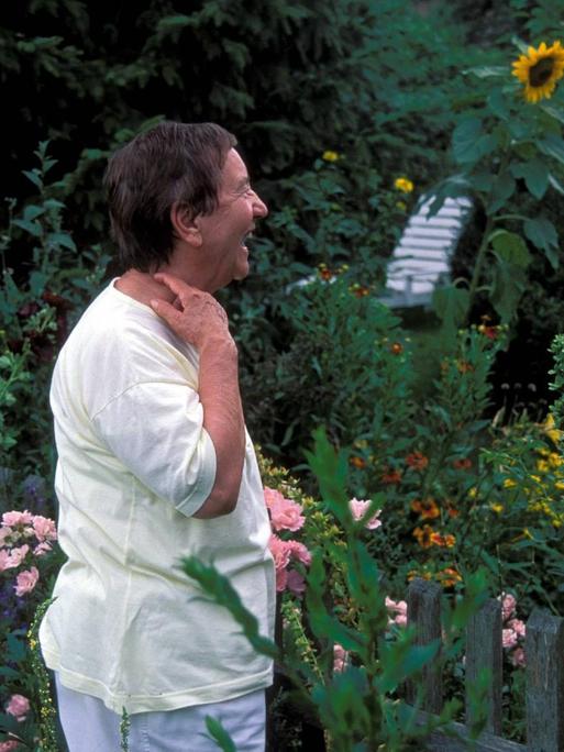 Nachbarinnen im Gespräch am Gartenzaun.