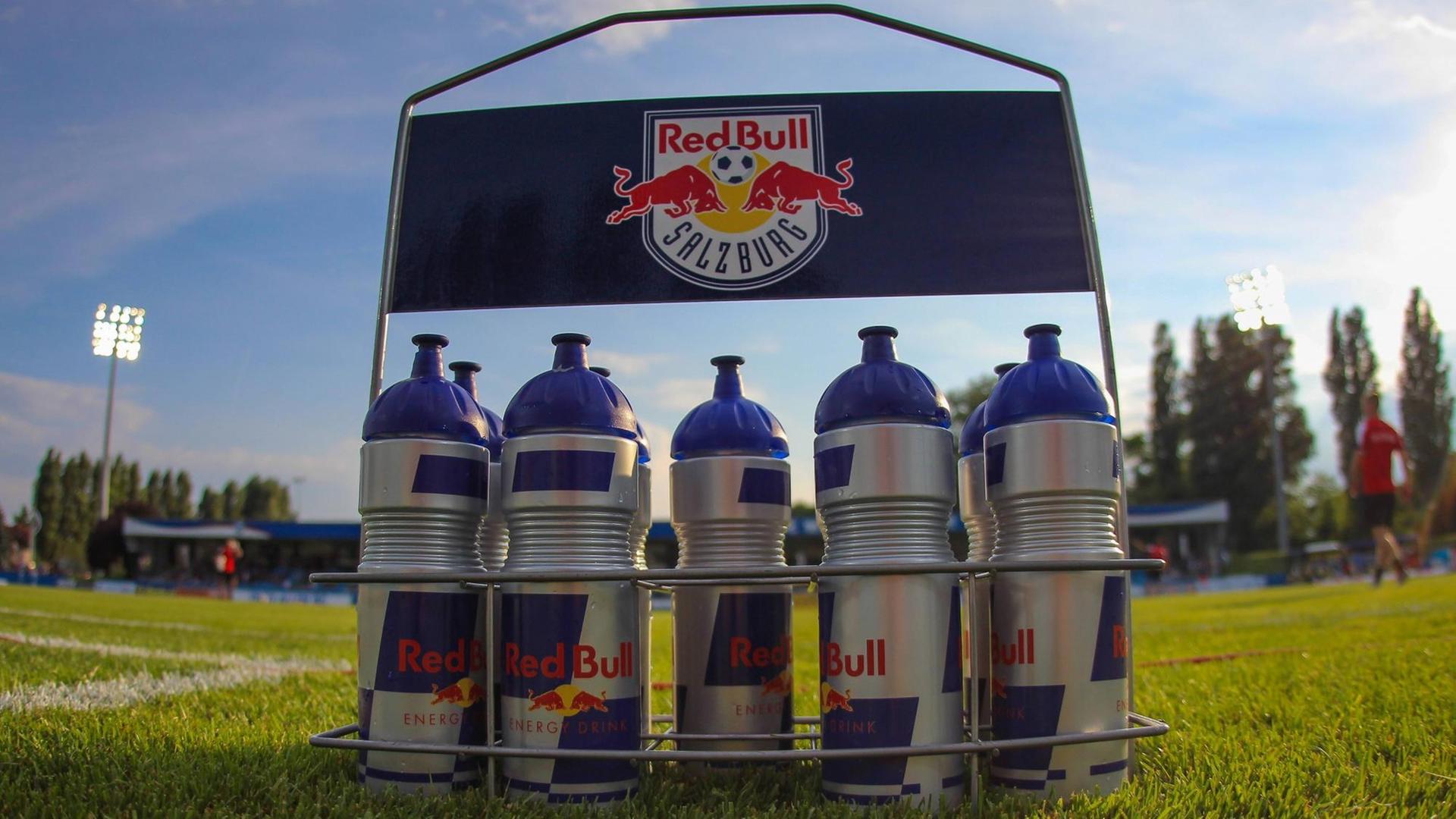 Sportler-Trinkflaschen in einem Halter mit dem Aufdruck "Red Bull Salzburg" stehen auf einem Fußballplatz