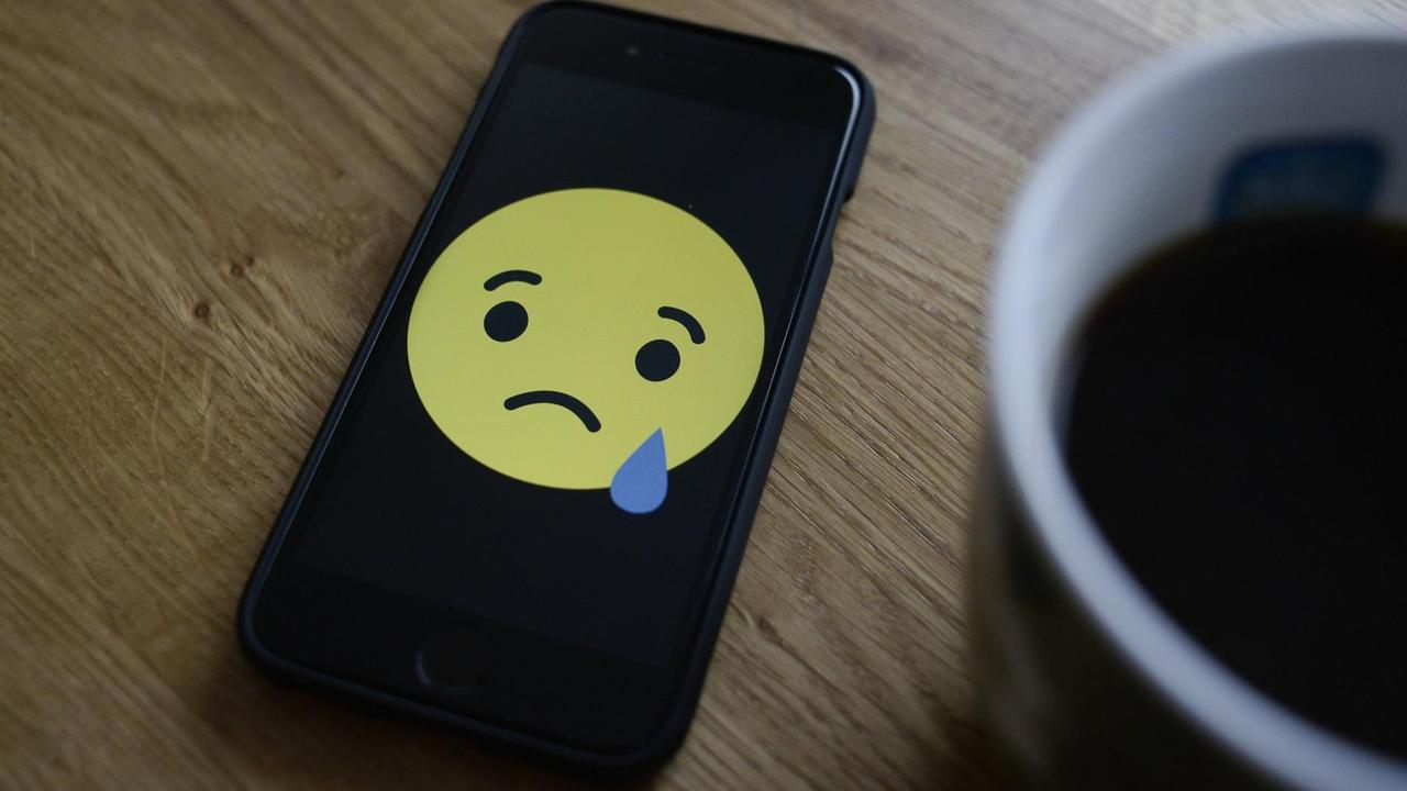 Ein trauriger Smiley auf einem Handy.