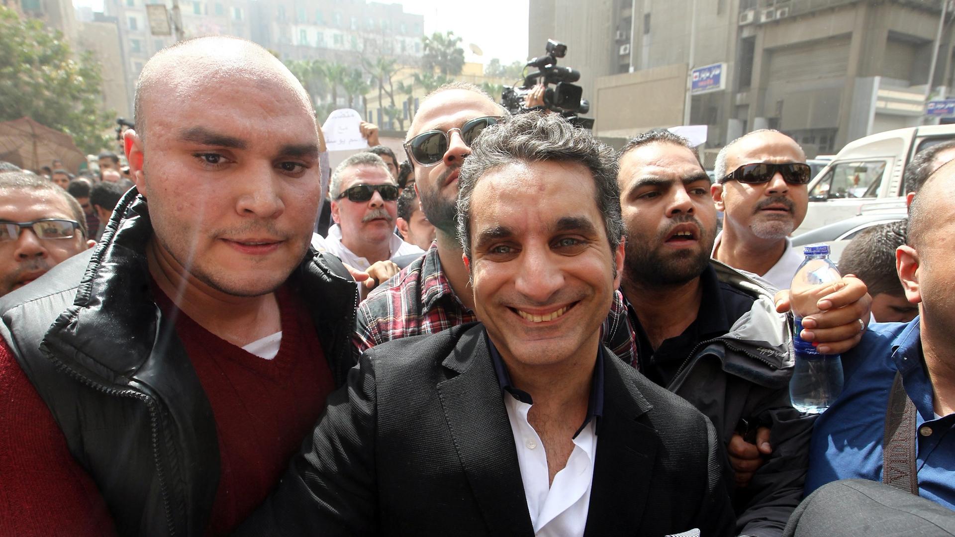 epa03645903 Egypt's popular TV satirist Bassem Youssef is surrounded by media and activists as he arrives at the high court in Cairo, Egypt, 31 March 2013. Youssef appeared before prosecutors for an investigation of alleged defamation of Islam and Preside epa03645903 Egypt's popular TV satirist Bassem Youssef is surrounded by media and activists as he arrives at the high court in Cairo, Egypt, 31 March 2013. Youssef appeared before prosecutors for an investigation of alleged defamation of Islam and Preside