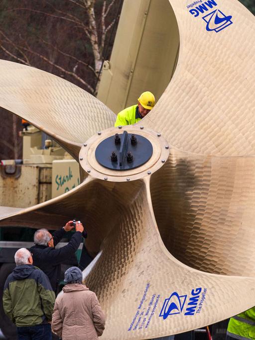 Ein 32 Tonnen schwerer Schiffspropeller mit einem Durchmesser von sieben Metern aus der Gießerei Mecklenburger Metallguss in Waren an der Müritz (Mecklenburg-Vorpommern) wird am 19.12.2014 mit Hilfe von zwei Kränen aufgestellt.
