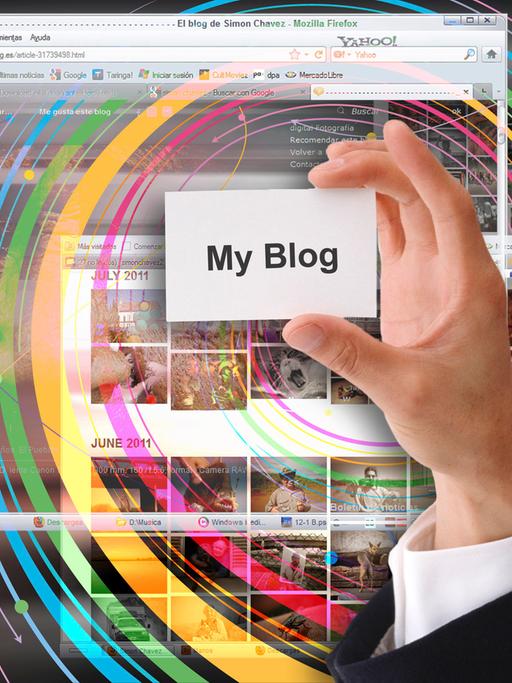 Ein Hand hält ein Schild auf dem "My Blog" steht vor einem Bildschirm. 