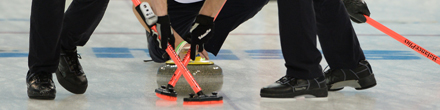 Die deutschen Curler schrubben rund um den Curlingstein auf der Eisfläche. Die deutschen Curler schrubben rund um den Curlingstein auf der Eisfläche.