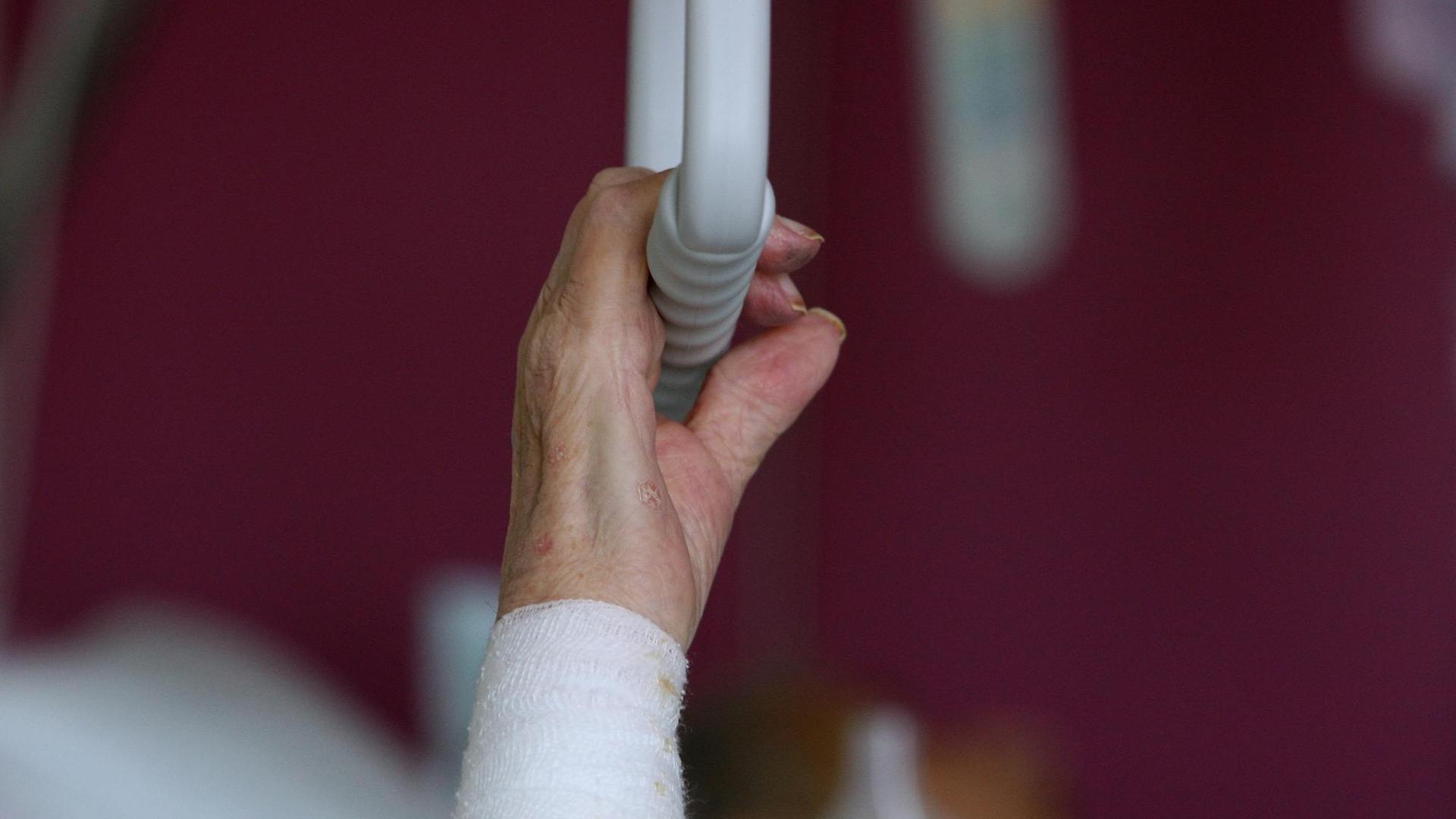 Die Hand einer pflegebedürftigen älteren Patientin greift am Dienstag (12.02.2008) im Krankenhaus von Dachau (Oberbayern) nach einem Haltegriff über dem Bett.