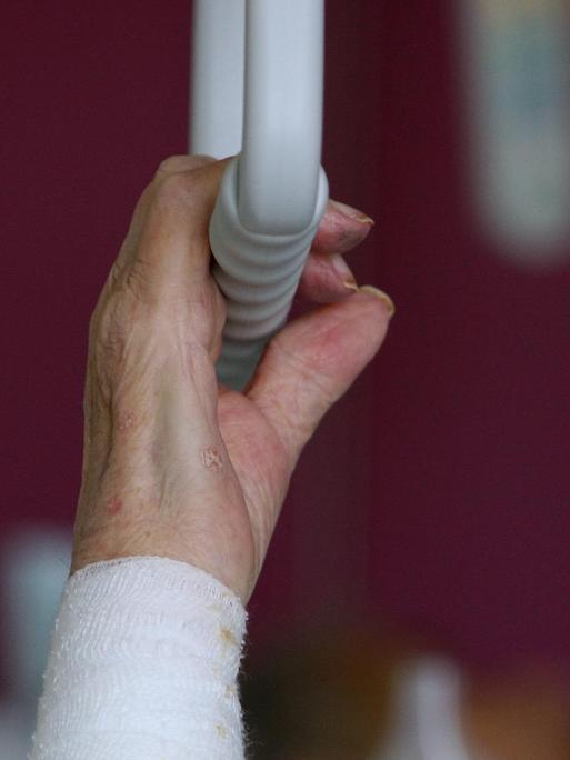 Die Hand einer pflegebedürftigen älteren Patientin greift am Dienstag (12.02.2008) im Krankenhaus von Dachau (Oberbayern) nach einem Haltegriff über dem Bett.