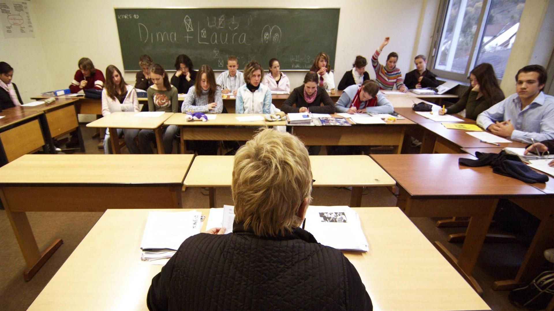 Eine Lehrerin sitzt vor ihrer Klasse.