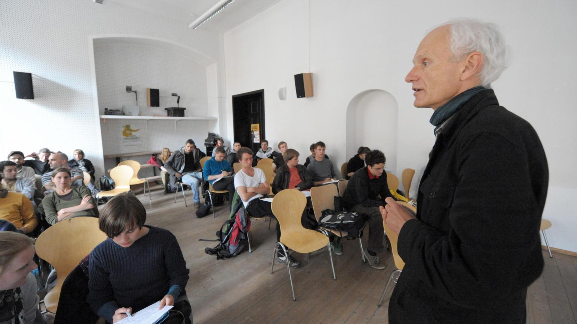 Christoph Türcke spricht in einem Seminarraum vor Studierenden.