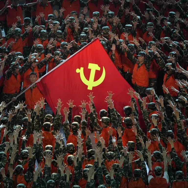 Als Rettungskräfte verkleidete Darsteller versammeln sich um eine Fahne der Kommunistischen Partei während einer Gala-Show im Vorfeld des hundertjährigen Jubiläums der Gründung der Kommunistischen Partei Chinas. 