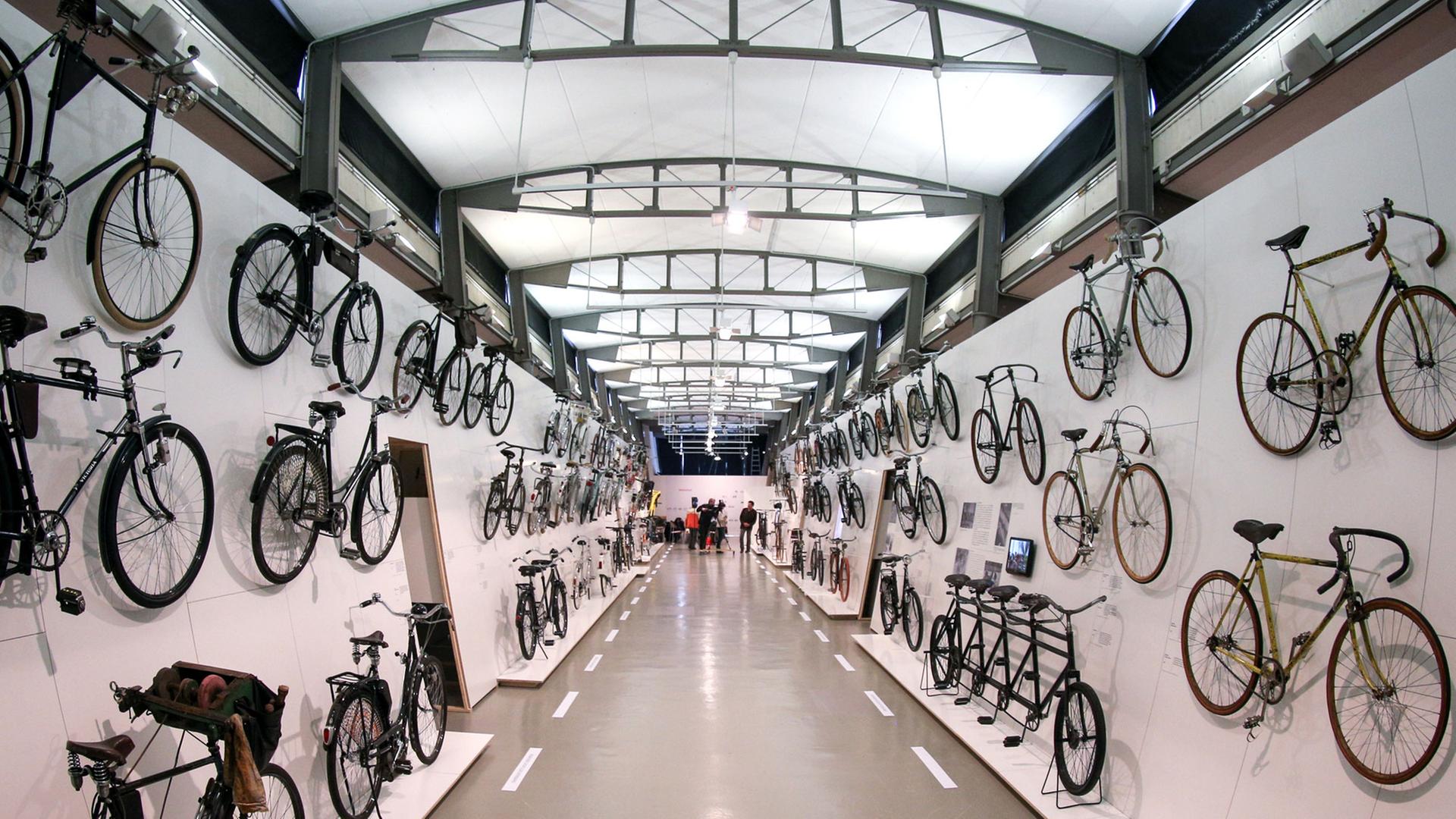 Fahrräder aus diversen historischen Epochen hängen in Hamburg im Museum für Arbeit an den Ausstellungswänden. Das Museum zeigt die Ausstellung "Das Fahrrad - Kultur, Technik, Mobilität".