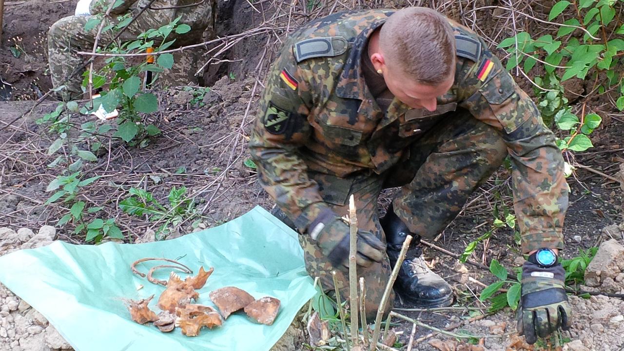 Bundeswehrsoldat sichert sterbliche Überreste eines Wehrmachtssoldaten auf dem Askoldowa-Mogila-Friedhof in Kiew.