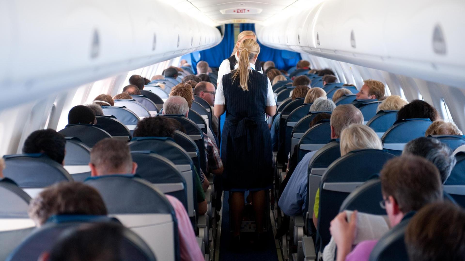 Flugbegleiterinnen im Gang eines Passagierflugzeugs