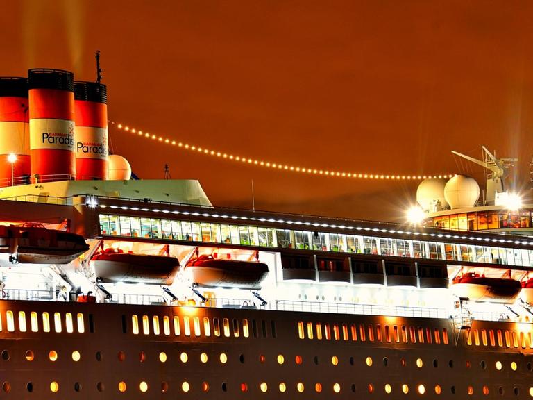 Ein Kreuzfahrtschiff mit seinen beleuchteten Decks (Symbolbild).