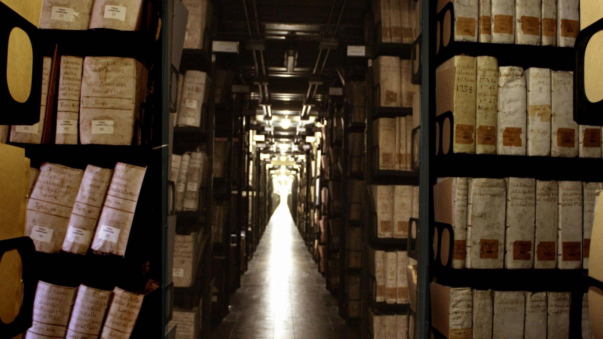 Lange Regalreihen voller alter Folianten säumen einen Gang im Vatikanischen Archiv