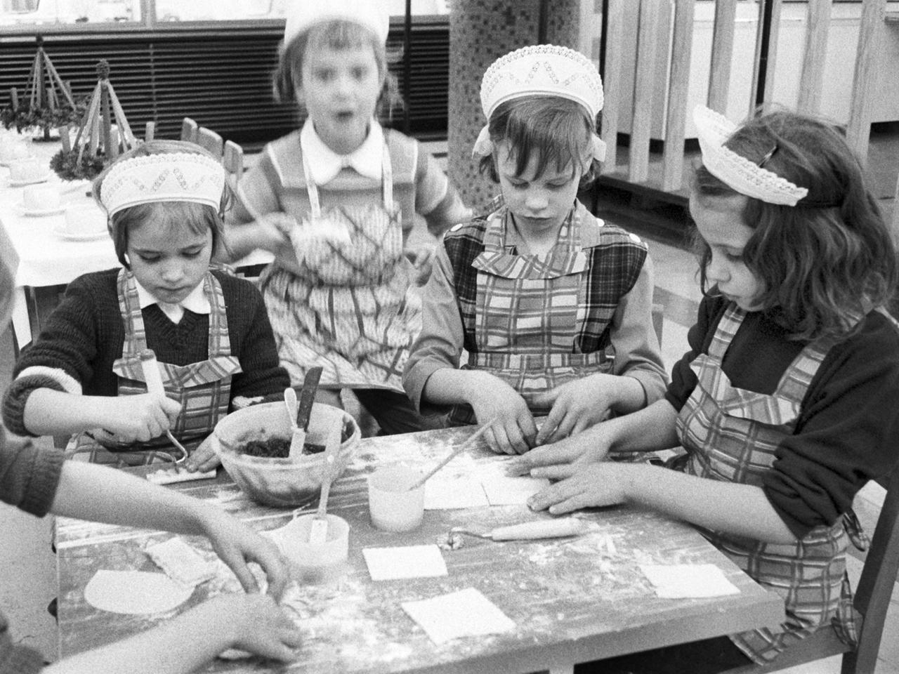 Eine Gruppe Kinder beim Backen in einer Lehrküche in Stuttgart am 30.11.1964.