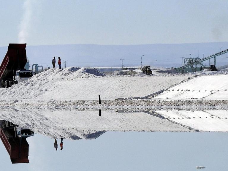 Menschen und Fahrzeuge spiegeln isch in Salzbecken des Lithiums-Abbaus in Atacama, nahe Calama city, in Chile.