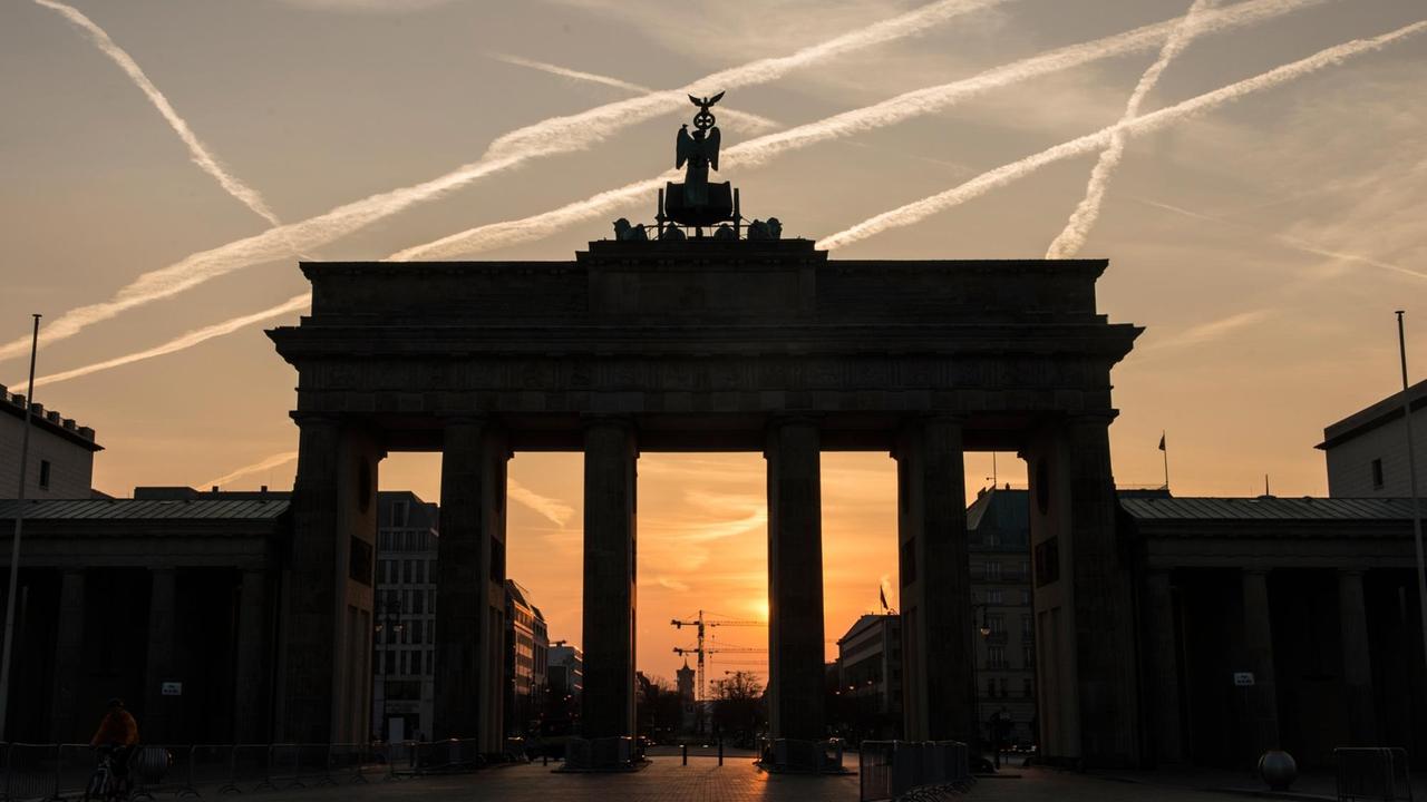 Im Licht der aufgehenden Sonne ist am 02.04.2017 in Berlin das Brandenburger Tor nur als Silhouette zu erkennen.