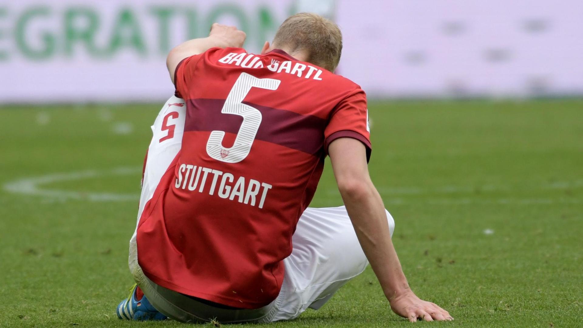 Stuttgarts Timo Baumgartl sitzt nach dem Spiel auf dem Boden.