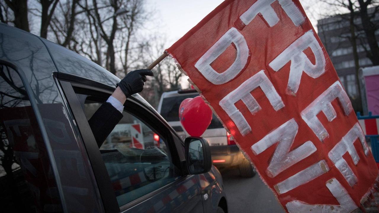 Ein Autokorso in Berlin. Aus einem Fenster hält jemand eine Fahne mit der Aufschrift "Free Deniz".