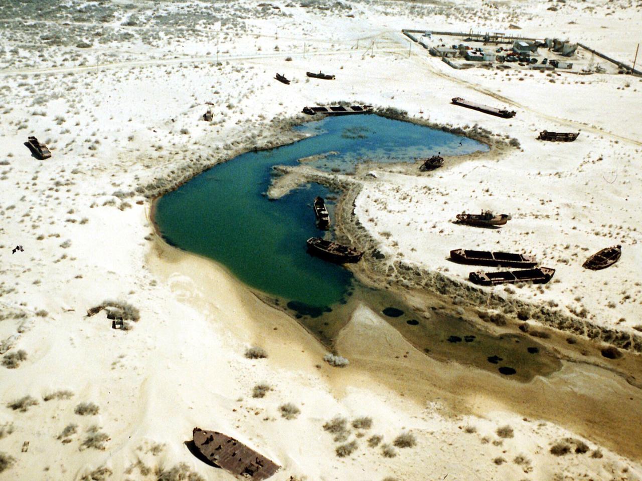 Boote auf dem Trockenen in einem Gebiet, das früher vom Wasser des Aralsees bedeckt war, aufgenommen in Usbekistan 1996. Der Aralsee gehört zu den früheren Sowjetrepubliken Kasachstan (im Norden) und Usbekistan (im Süden des Sees). Er war usprünglich mit 65000 Quadratkilometern fast so groß wie Bayern, hat aber seit 1969 mehr als 40 Prozent seiner Fläche verloren. Frühere Hafenstädte liegen heute in Salzwüsten, die bis zu 50 Kilometer vom Ufer entfernt sind. Ursache ist eine zu große Wasserentnahme aus den beiden Zuflüssen Amu Darja und Syr Darja zur Bewässerung der Baumwollplantagen in beiden Ländern.