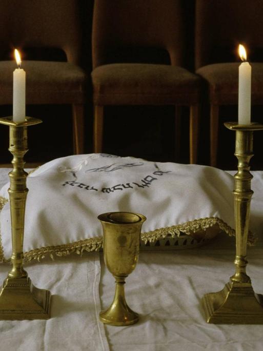 Gedeckter Tisch am Freitagabend (Beginn des Sabbats) mit angezündeten Kerzen und zwei Laiben Brot (Challa).