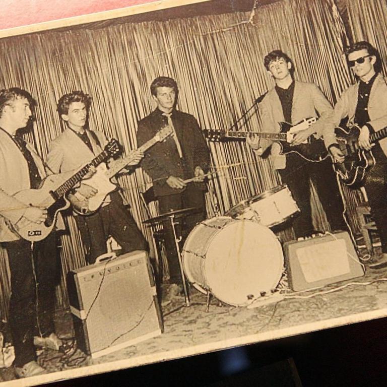 Eine Schwarzweißfotografie auf Papier zeigt die Beatles bei ihrem ersten Auftritt im Hamburger Indra-Club am 17. August 1960.