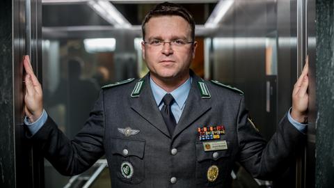 Das Bild zeigt den Vorsitzenden des Deutschen Bundeswehrverbands, André Wüstner, der in einem Aufzug posiert.