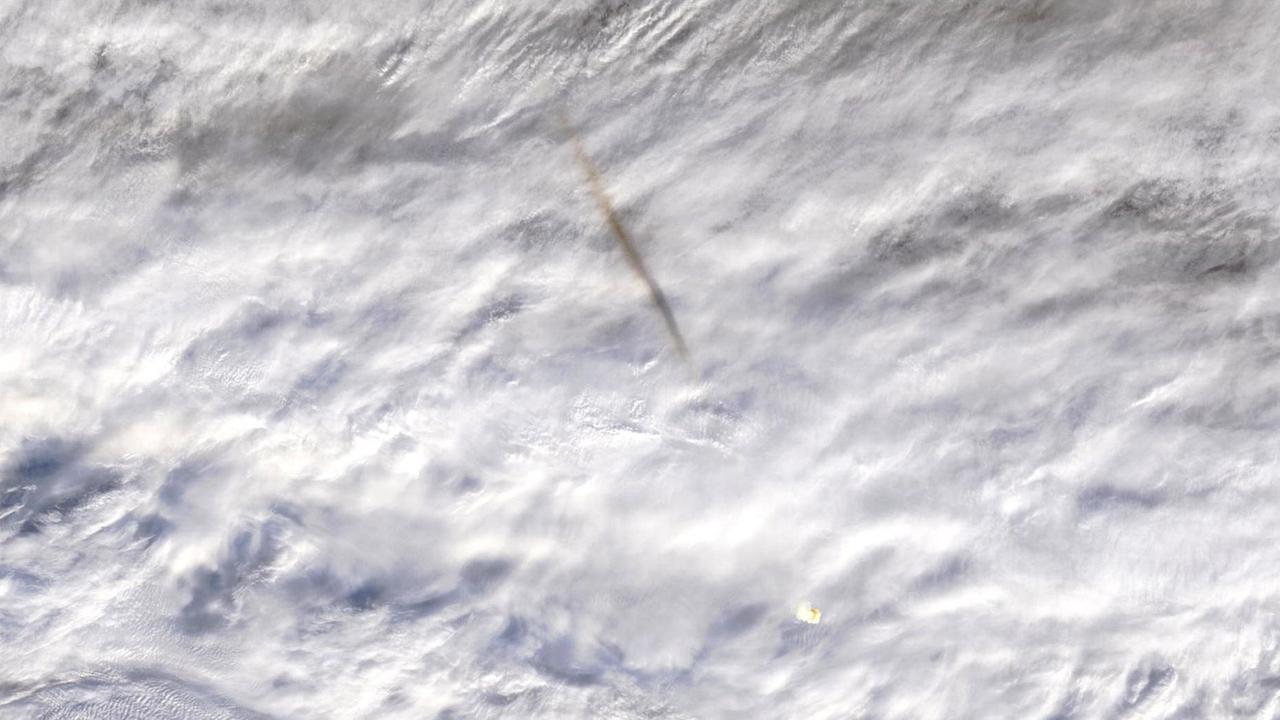 Der explodierende Asteroid (unten) und seine Rauchspur, aufgenommen von einem Wettersatelliten (NASA)