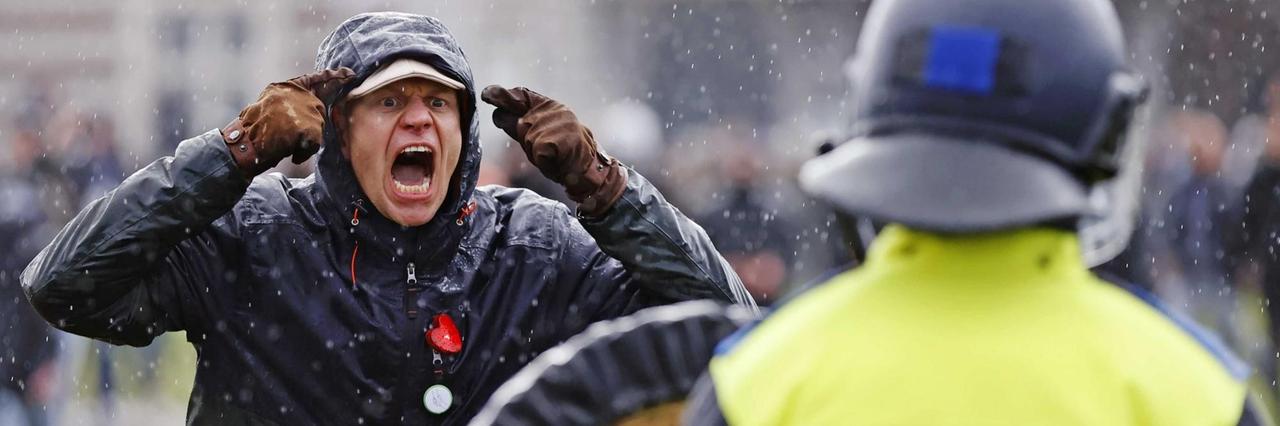 Ein regierungskritischer Demonstrant steht bei einer Kundgebung am Museumsplatz einem Polizisten gegenüber. Ein regierungskritischer Demonstrant steht bei einer Kundgebung am Museumsplatz einem Polizisten gegenüber.