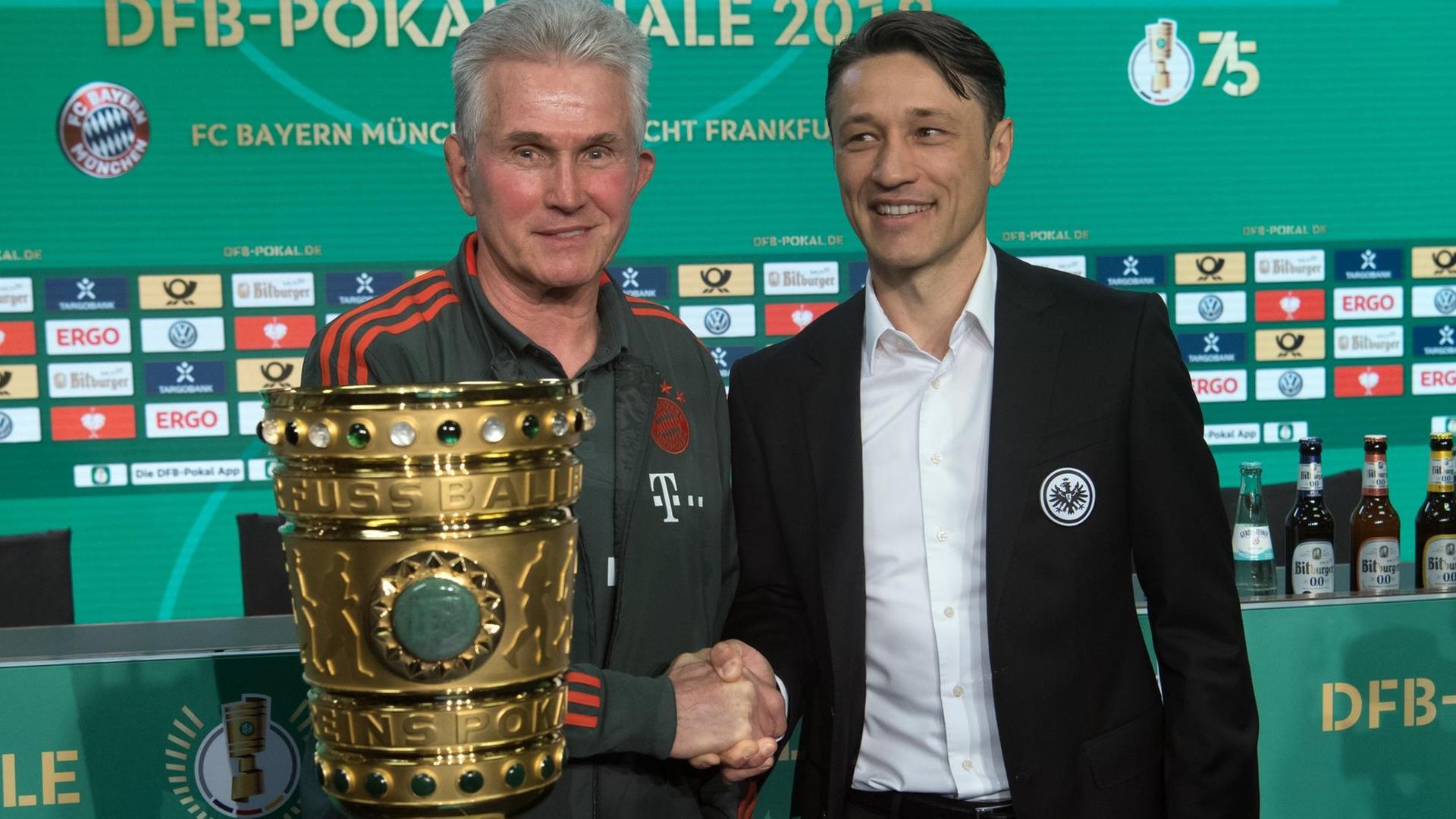 Jupp Heynckes (l), Trainer des FC Bayern München, und Niko Kovac, Trainer von Eintracht Frankfurt, stehen nach der Pressekonferenz zum DFB-Pokalfinale zwischen dem FC Bayern München und Eintracht Frankfurt am 19.05.2018 hinter dem Pokal.