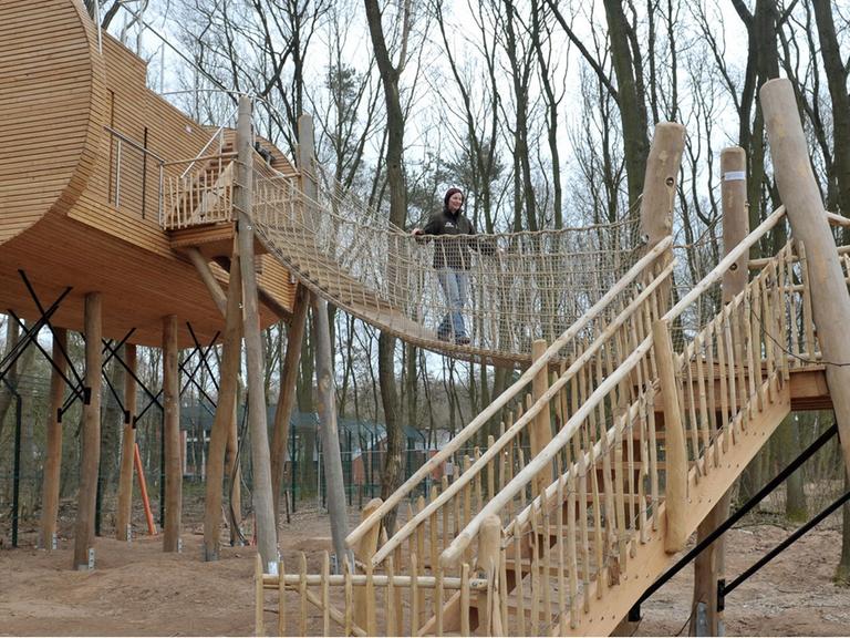 Christina Faß geht am Montag (02.04.2012) über eine Hängebrücke vom neuen Baumhaushotel im Wolfcenter in Dörverden, das sie mit ihrem Mann gegründet hat. In sicherer Höhe kann man direkt auf ein Gehege mit Wölfen blicken.