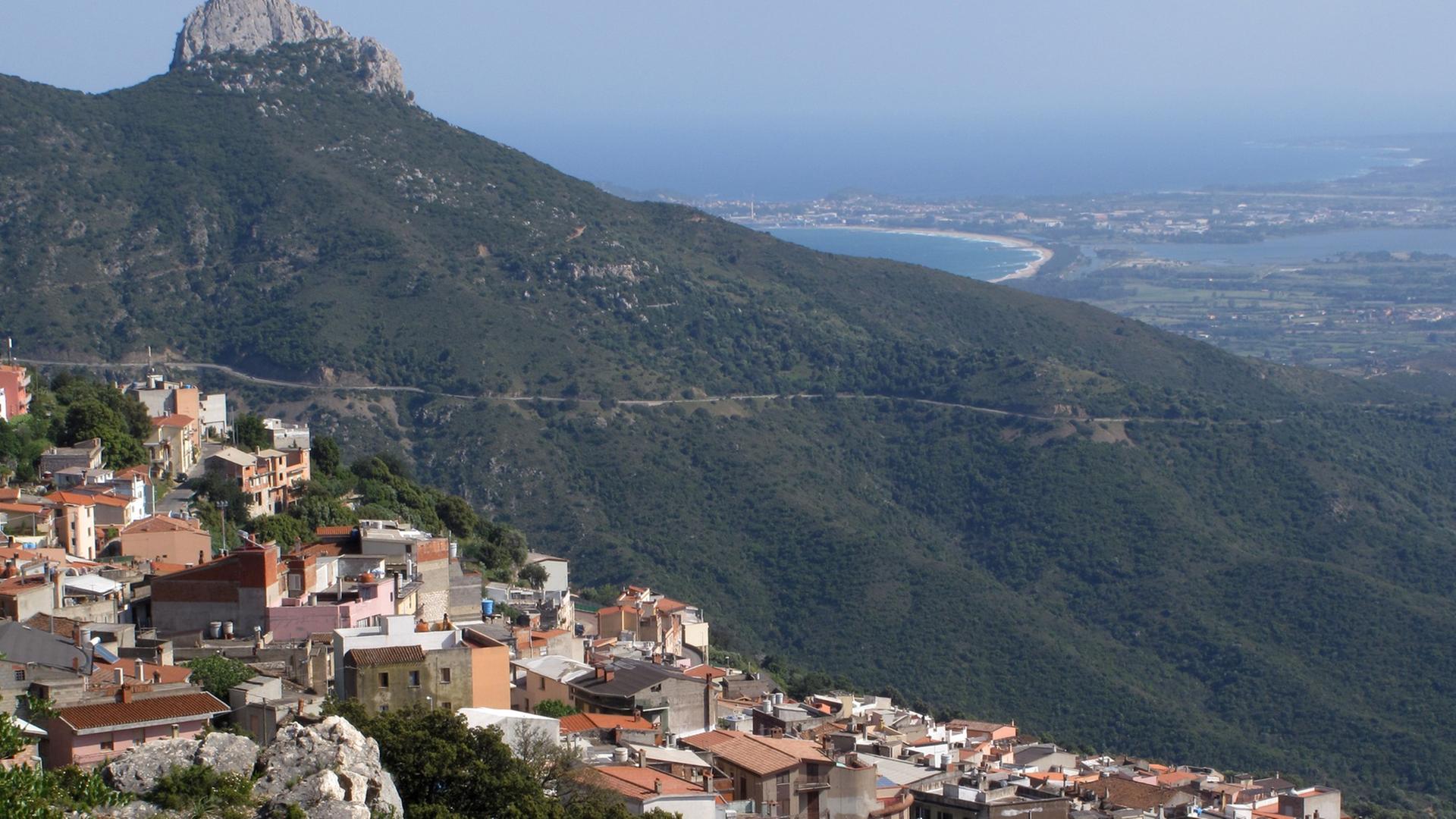 Blick auf die an einem Berghang gelegene Ortschaft Baunei in Sardinien.