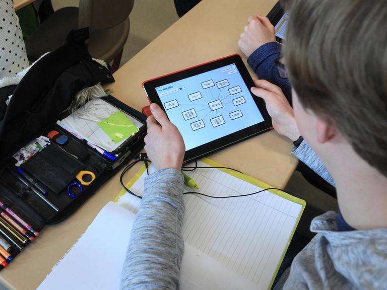 Ein Schüler arbeitet mit einem speziellen Tablet im Unterricht